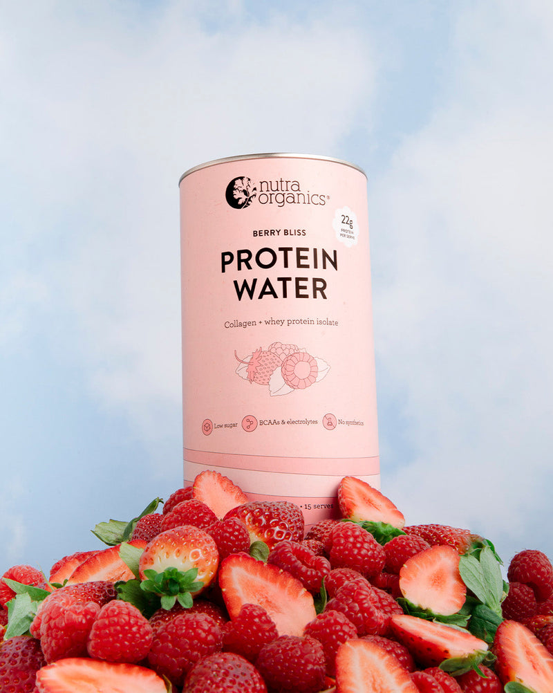 Berry Bliss Protein Water container with strawberries on a light blue background