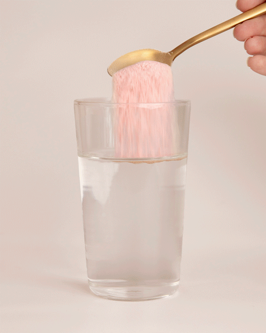 Collagen Beauty powder being stirred into a glass of water