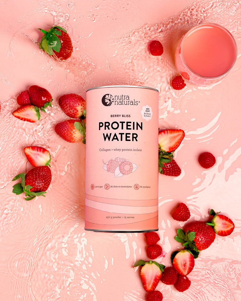 Protein water canister with strawberries and a glass of protein water drink 