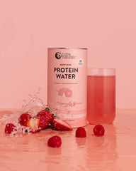 Protein water can with strawberries and a glass of protein water drink