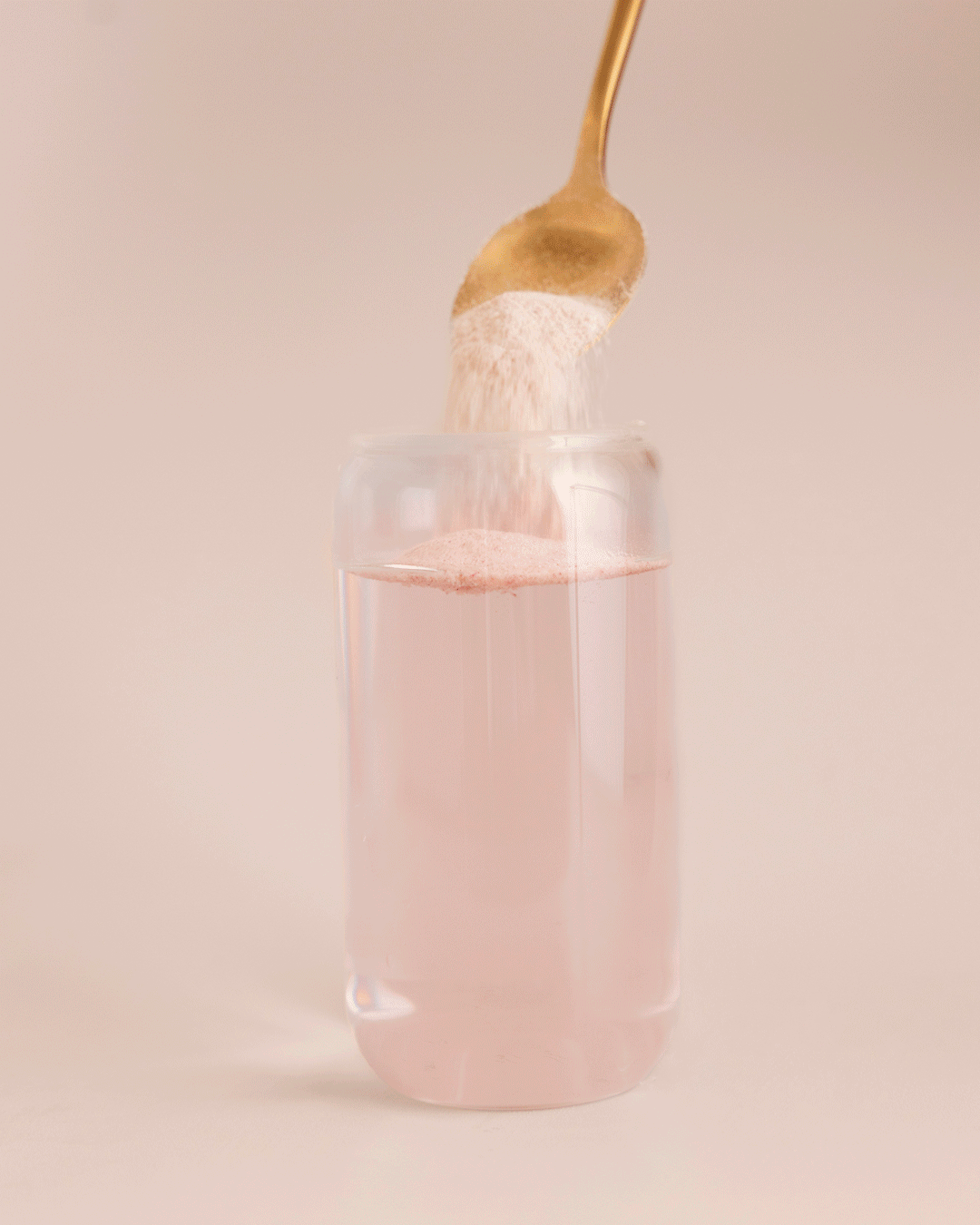 GIF: Berry Bliss Protein Water powder being stirred into a glass of water.