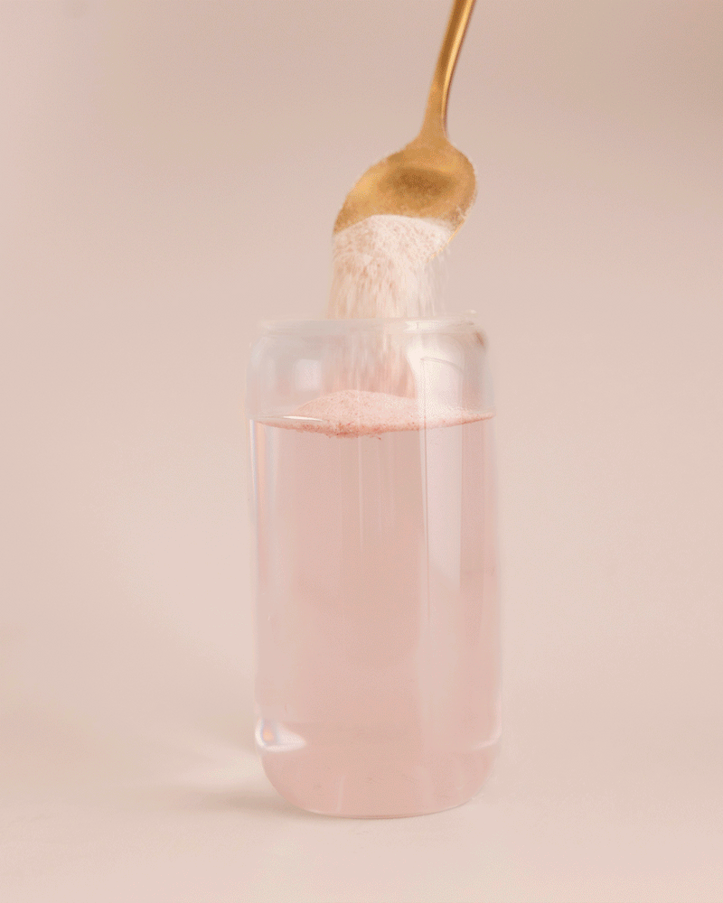 GIF: Berry Bliss Protein Water powder being stirred into a glass of water.
